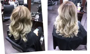 A woman's blonde hair styled in loose waves, viewed from the back.