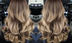 Vackert balayage hår med mjuka vågor och gyllene toner.
