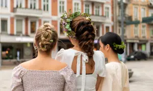 Tre kvinnor med vackra frisyrer, en med blomsterkrans, en med flätor och en med knut, visar upp sina hår.