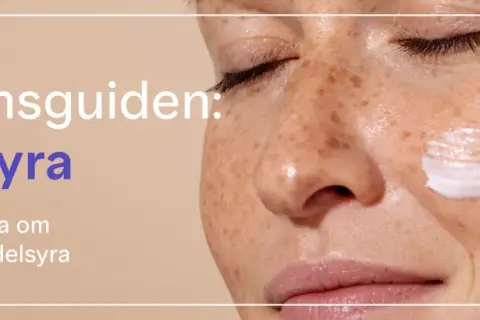 En närbild på en kvinna med fräknar som applicerar kräm. Texten lyder "Ingrediensguiden: Mandelsyra".