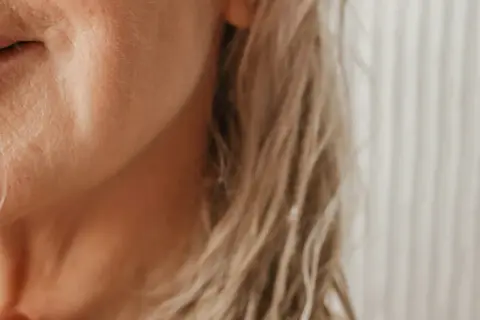 När huden blir torrare och håret torrt hår klimakteriet, kan en fin tråd av hår synas mot kinden.