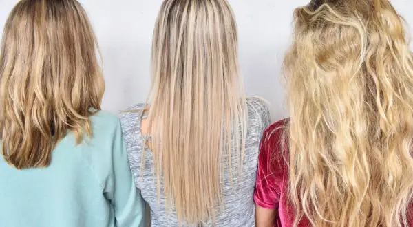 Tre personer med olika nyanser av varma blonda slingor. En med ljusblont, en med mellanblont och en med mörkblont hår.