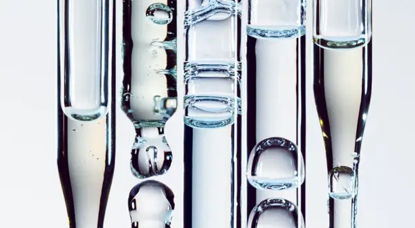 Droppar av serum med bubblor i pipetter, en visuell representation av aktiv hudvård.