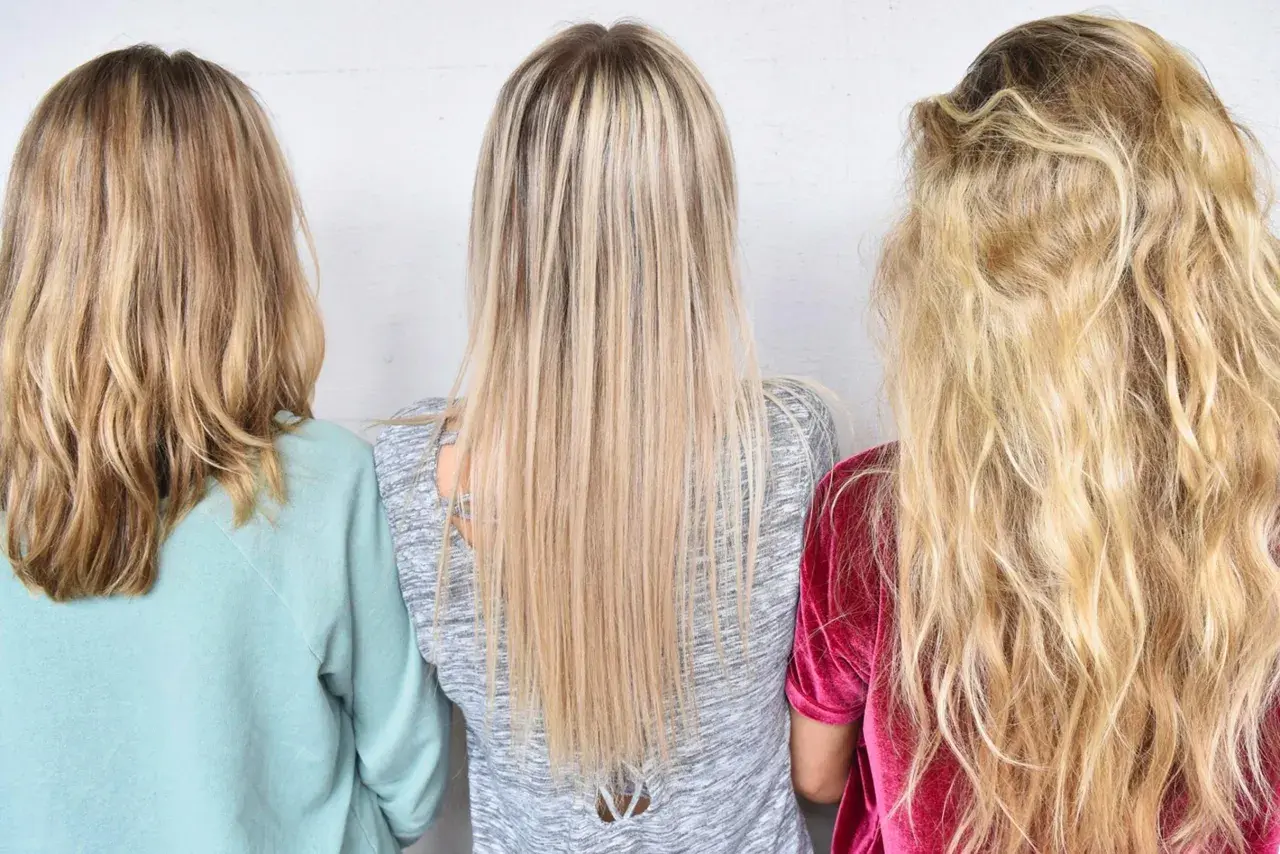 Tre personer med olika nyanser av varma blonda slingor. En med ljusblont, en med mellanblont och en med mörkblont hår.