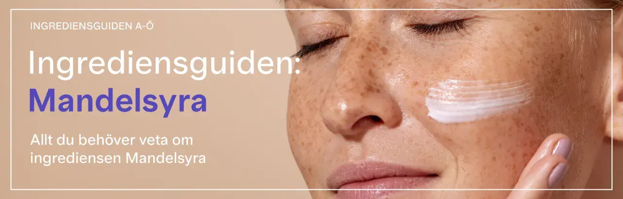 En närbild på en kvinna med fräknar som applicerar kräm. Texten lyder "Ingrediensguiden: Mandelsyra".