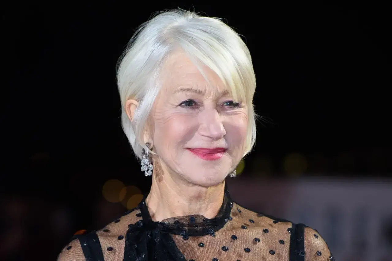 Helen Mirren med gr&aring;tt h&aring;r och korta frisyrer, str&aring;lar i en elegant svart kl&auml;nning.