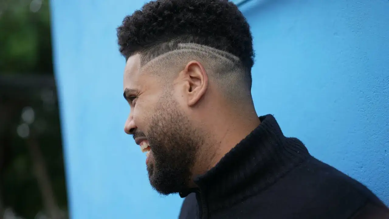 Man med kort h&aring;r och en snygg skin fade med linjer.