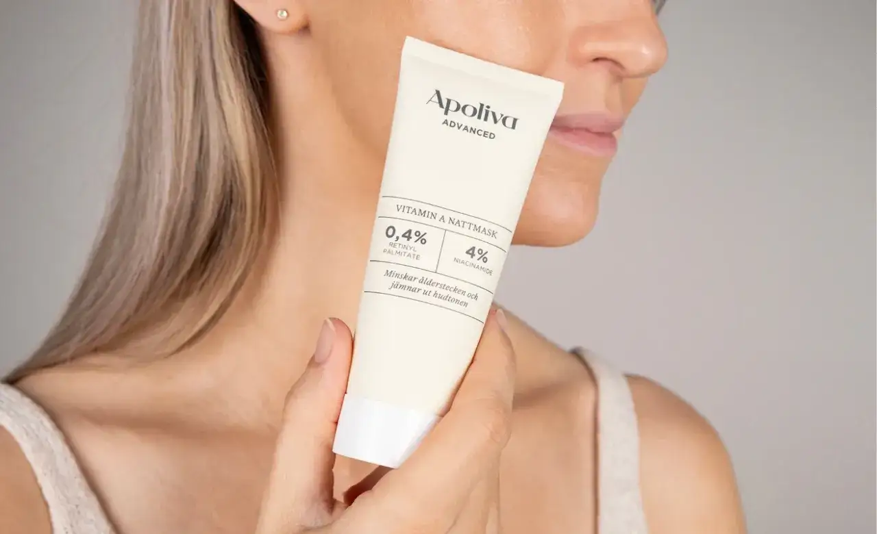 Kvinna håller en tub med Apoliva Vitamin A Nattmask. Denna produkt med retinol kan hjälpa mot akne och ålderstecken.