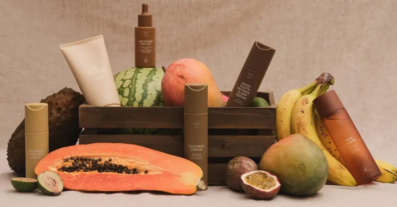 Frukter som mango, papaya och bananer omger hudv&aring;rdsprodukter. En hylla med aktiv hudv&aring;rd som serum och reng&ouml;ring.